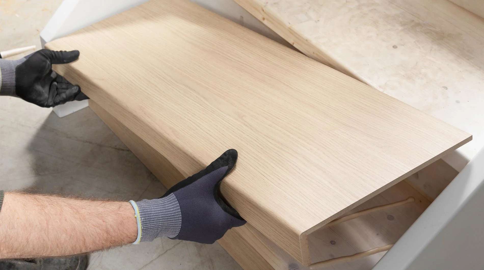 Monteur legt een PVC overzettrede op een bestaande traptrede